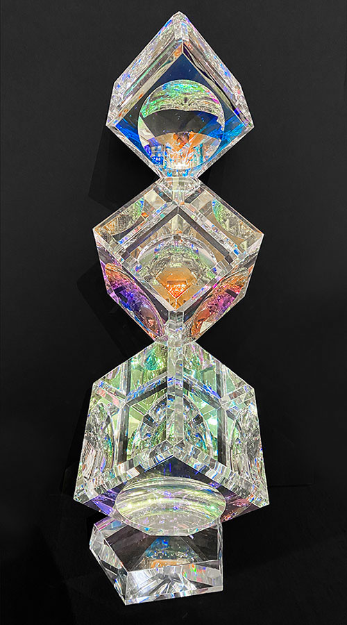 3 Tumbling Crystal Cubes by Harold Lustig. Lustig creates stunning crystal cubes with a dichroic film. This film refracts light and color and creates stunning rainbow colors.