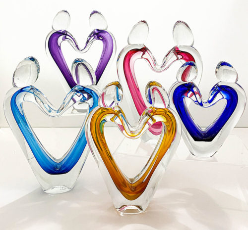 five glass heart sculptures in various colors