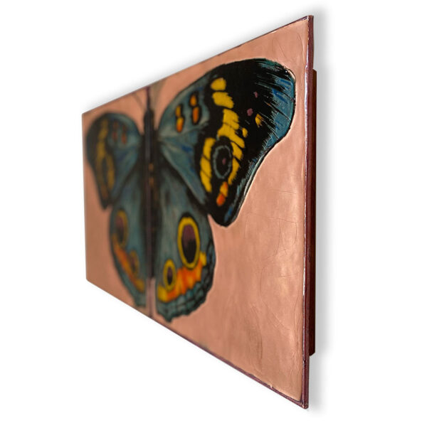 On the Wings Limited Edition by Houston Llew. Limited Edition wall art - copper attached to wood frame. Each piece is glass infused onto copper to create each stunning design. Featured on two 15" x 15" floating mount enameled panels, this stunning butterfly with lifelike details and colors is sure to bring any room to life!