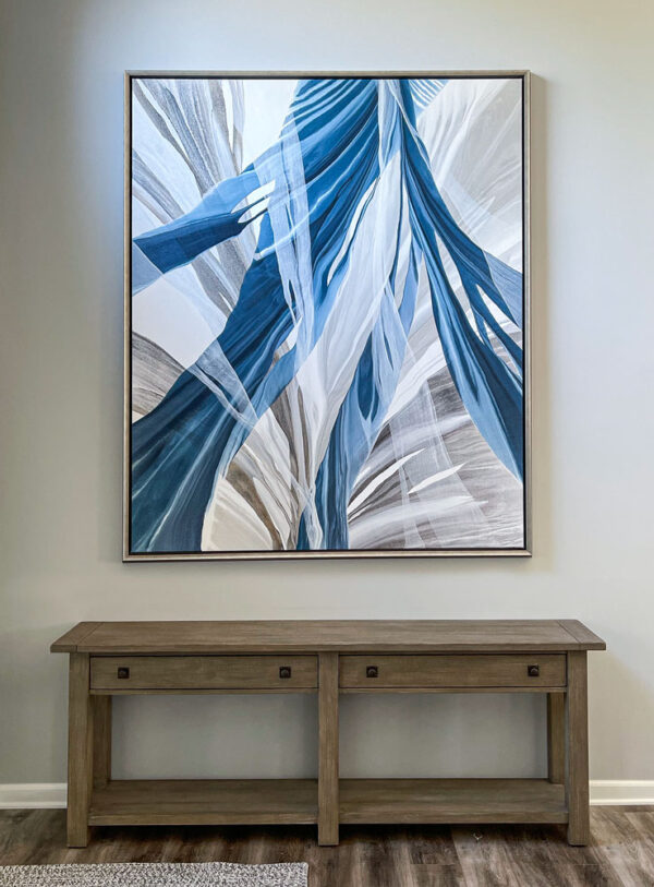Sherwood Falls by Antonio Molinari at Art Leaders Gallery. Blue and gray abstract poured painting framed and hanging above brown console. Interior design, framed artwork.