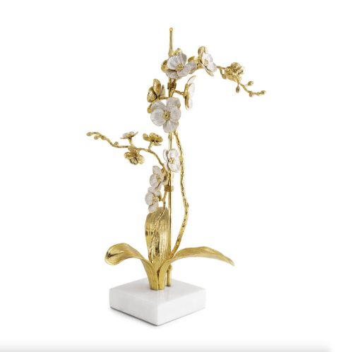 Large Orchid Stem, Item 130834 Artist: Michael Aram The Orchid Collection celebrates the ethereal spirit of the orchid plant. Symbolic of purity and grace, this collection captures the delicate nature of orchids while also expressing a quality of mystery and sensuality. "There is something so captivating about orchids. Rendered with white enamel over golden brass, each bloom glistens with quiet vibrance. The elegant composition of finishes creates a perfect balance, evoking a feeling of subtle luxury. Each stem feels so delicate and weightless, belying the fact that the pieces are forged in metal and anchored in marble, crafted to last an eternity." -M. Medium: Natural Brass & White Enamel with Marble Base Price: $525.00 Size: 11"L x 13"W x 22"H Base 5.5"L x 5.5"W x 1.5"H