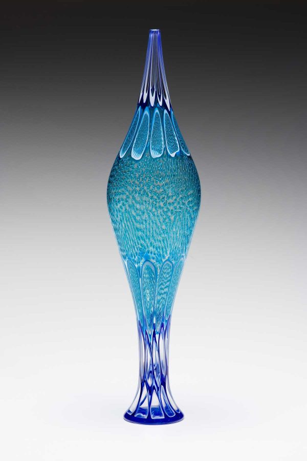 Ociean vessel from the Diva Series by American glass artist Kenny Pieper. 25 inch tall glass vessel with intricate teal or sage blue linework.